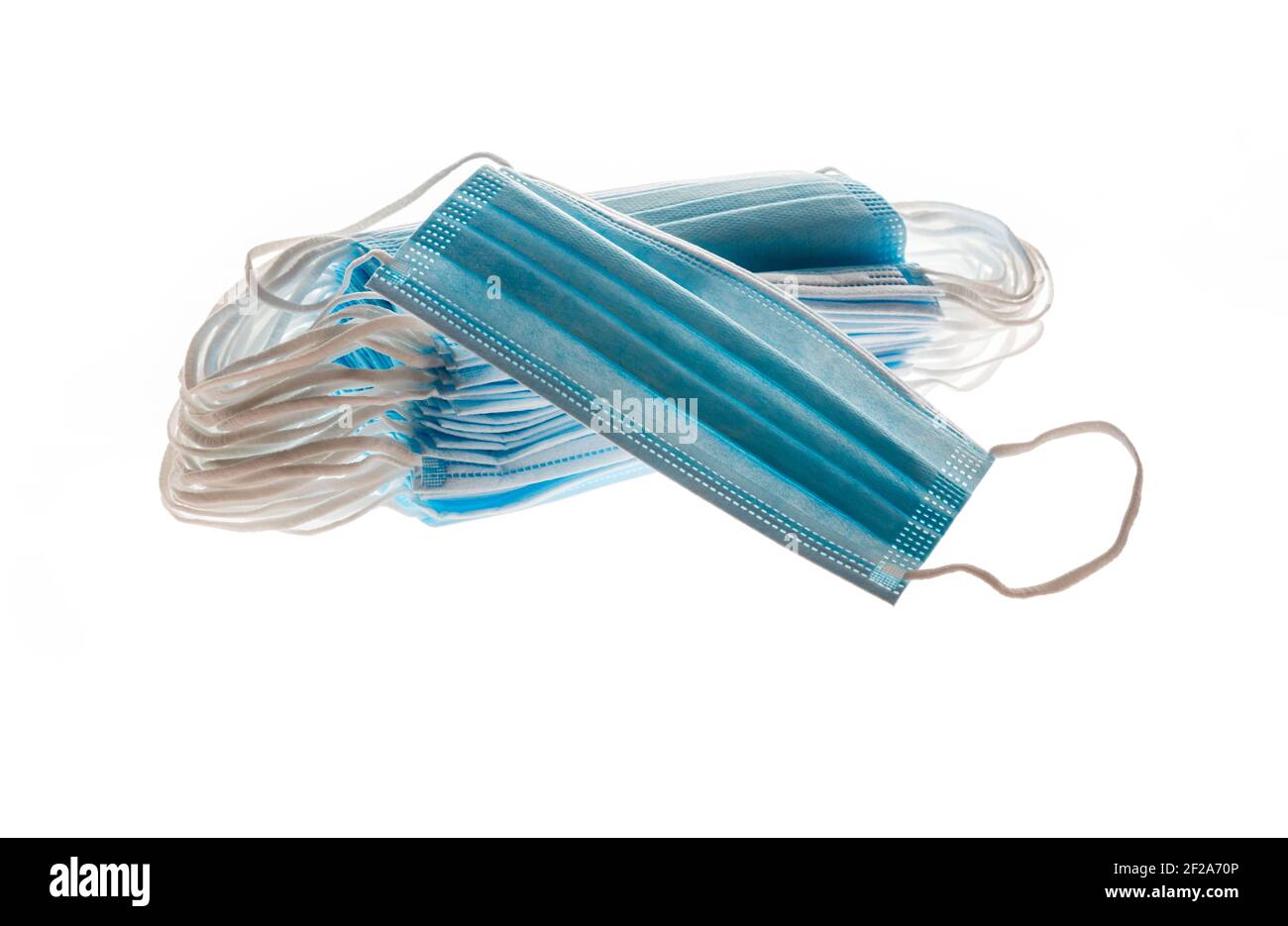 Masques médicaux bleus, comme protection contre les virus, isolés sur fond blanc, concept covid19. Banque D'Images