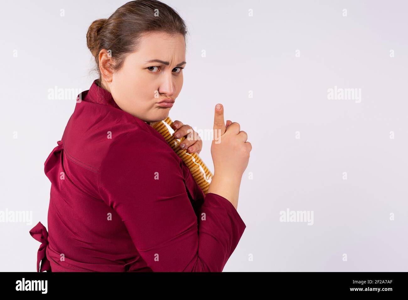 Une femme caucasienne choquée cache un paquet de biscuits dans ses mains et montre son doigt non Le désir n'est pas partagé. Dépendance aux bonbons. Obésité. Banque D'Images