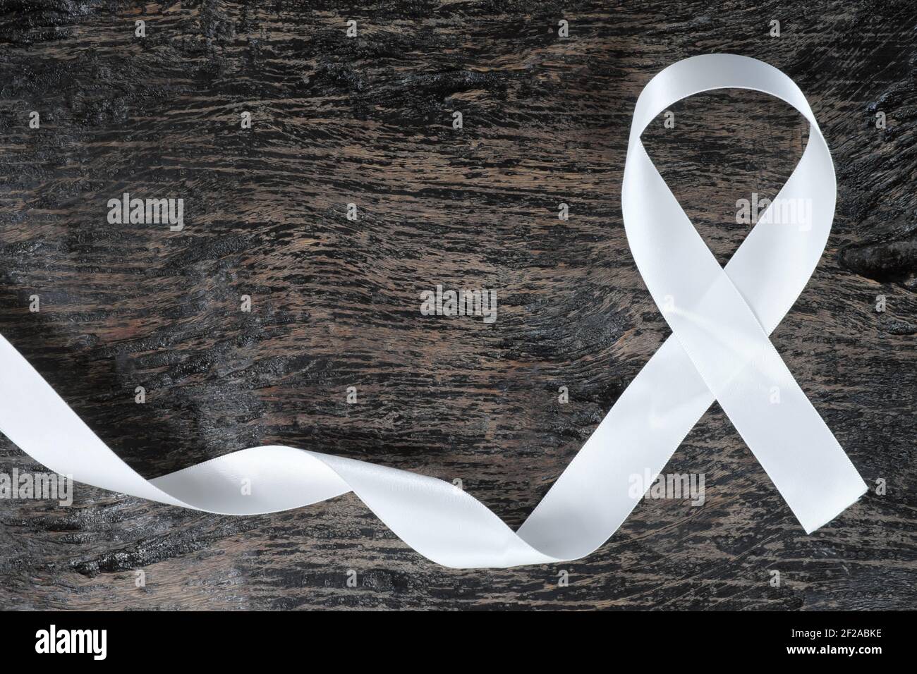 Vue de dessus du ruban blanc sur fond de bois sombre. Concept de sensibilisation au cancer du poumon. Banque D'Images