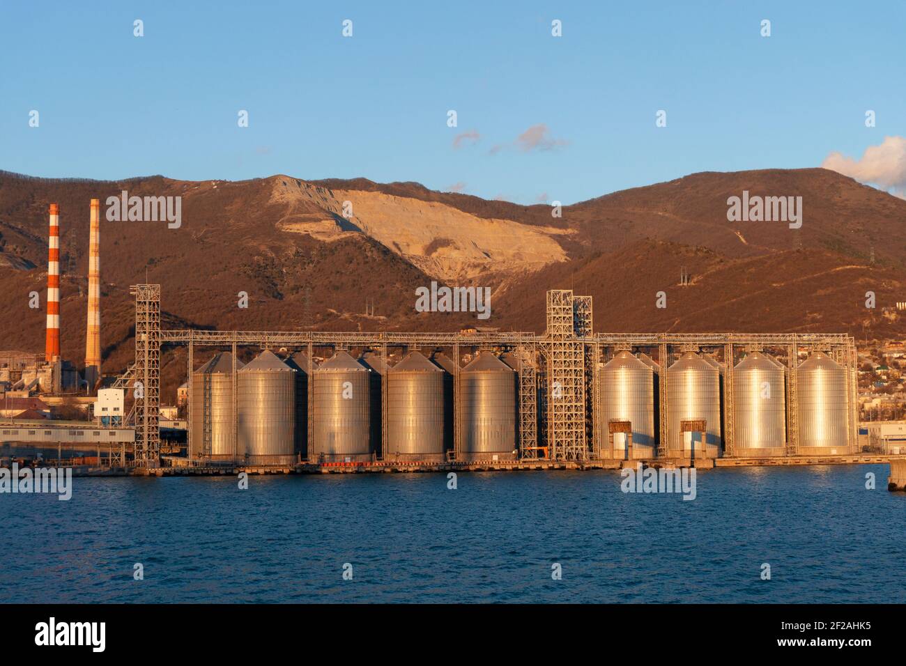 citernes pour le stockage du grain dans le port au bord de la mer en toile de fond de la montagne Banque D'Images