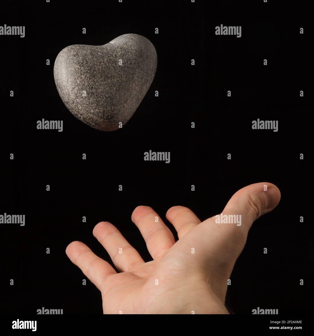 Une pierre en forme de coeur dans l'air à être attrapé dans la main, en forme de coeur, coeur de roche, l'amour est dans l'air, coeur de galet, jour de la Saint Valentin, 14 février, Banque D'Images Une pierre en forme de coeur dans l'air à être attrapé dans la main, en forme de coeur, coeur de roche, l'amour est dans l'air, coeur de galet, jour de la Saint Valentin, 14 février, Banque D'Images