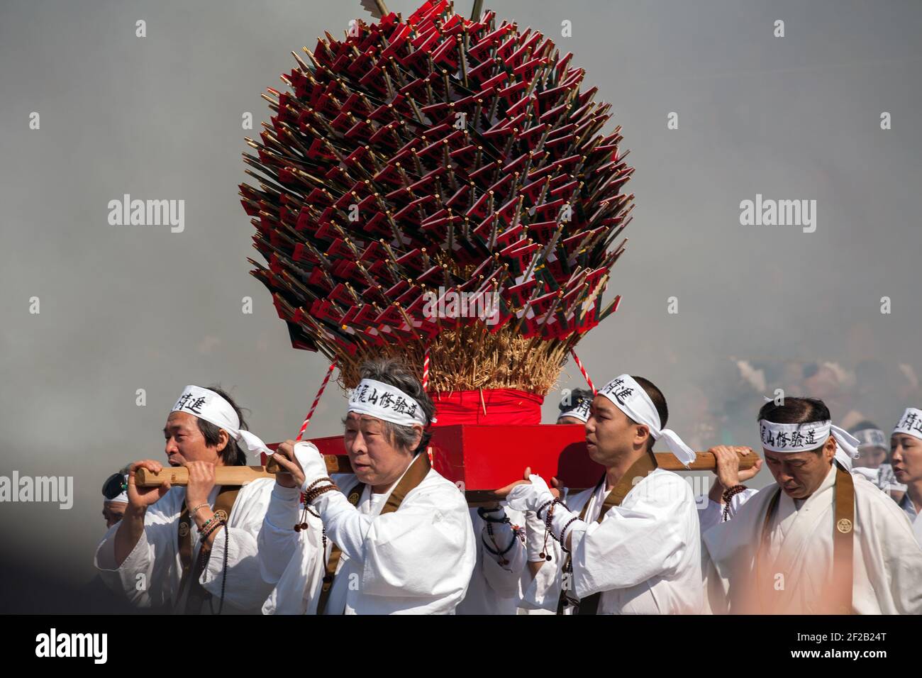 Yamabushi/Shugenja pèlerins transportant une civière de goma-gi/bâtons de prière au Hiwatari Matsuri - Festival de marche au feu, Mont Takao, Hachioji, Japon Banque D'Images