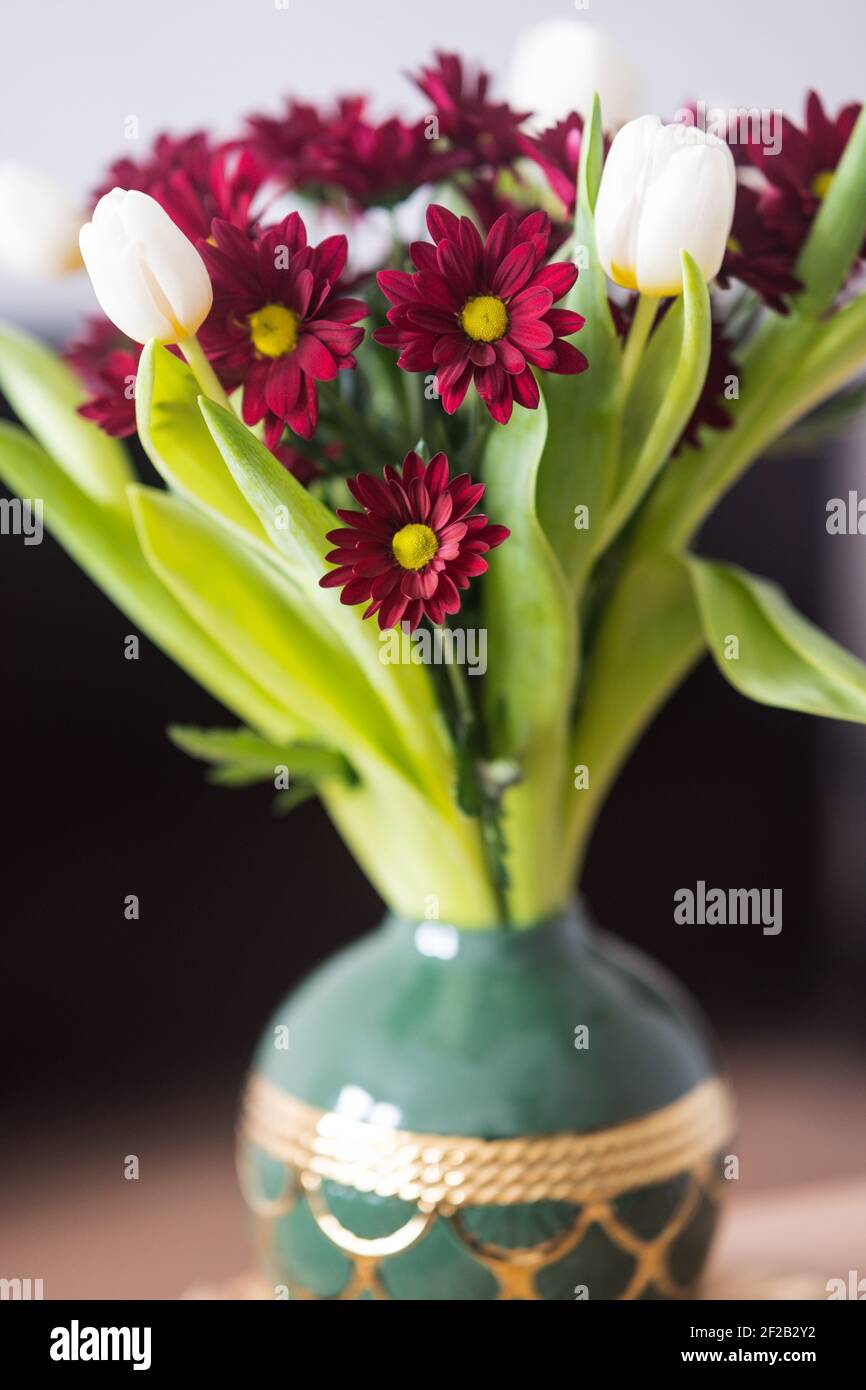 Bouquet de tulipes et de chrysanthèmes dans un vase sur fond blanc. Banque D'Images
