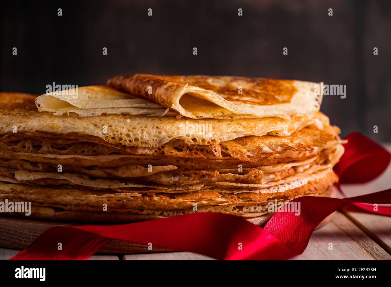 Une pile de crêpes fines sur un fond en bois sombre de gros plan. Un plat traditionnel de crêpes pour les vacances Maslenitsa. Place pour votre texte, photo pour Banque D'Images