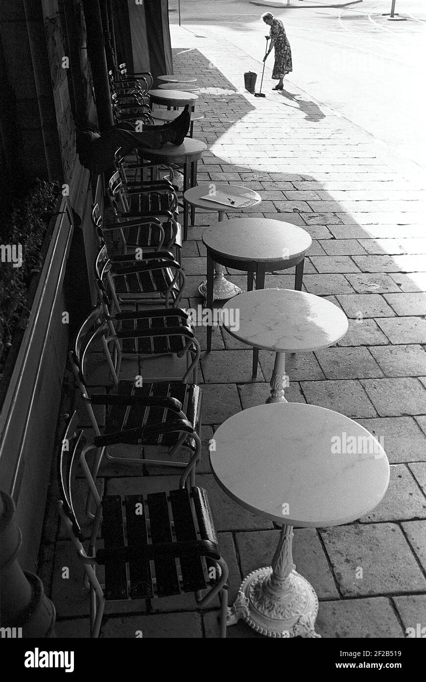 Dans les années 1950. Une femme travaille à l'extérieur en frottant le trottoir devant un restaurant extérieur. Suède 1953. Réf. Pärm 1 Banque D'Images