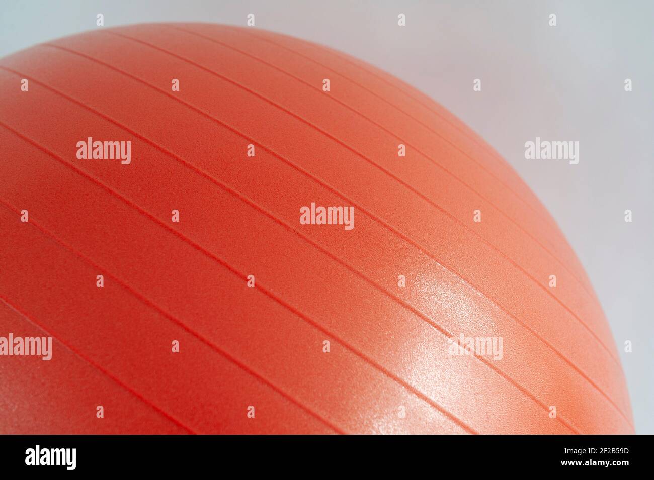 Photo détaillée d'un ballon de gym gonflable rouge sur fond blanc. Banque D'Images