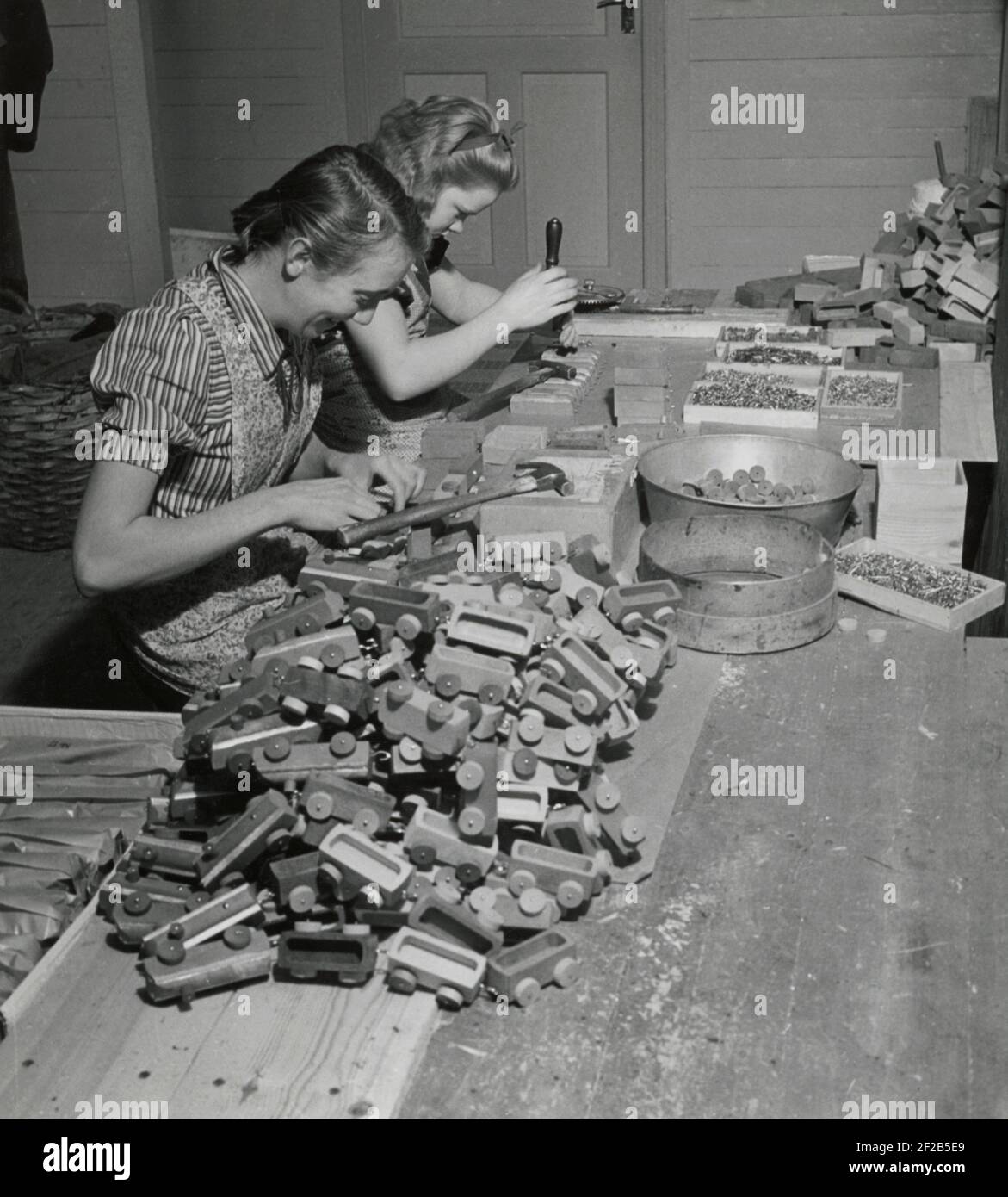 Fabrication de jouets dans les années 1940. Intérieur de l'usine du fabricant suédois de toymaker Westroths i Kulltorp. Deux femmes sont montées des roues sur les trains de jouets en bois qui étaient des jouets classiques pour enfants. Suède 1940 Banque D'Images