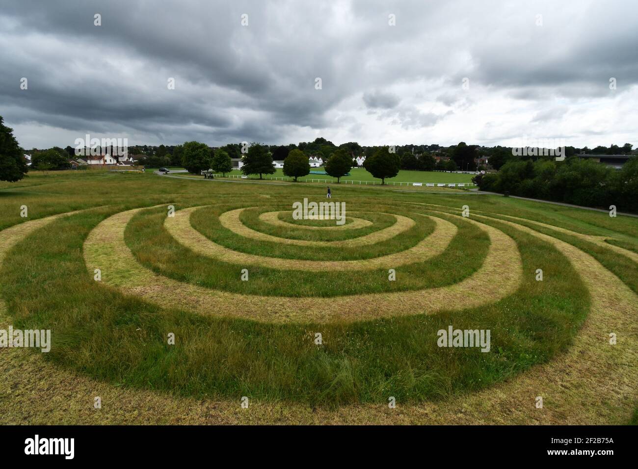 Chemin en spirale coupé dans l'herbe sur le Old Showfield dans Frome sous un ciel sombre menaçant.Frome. Somerset Banque D'Images