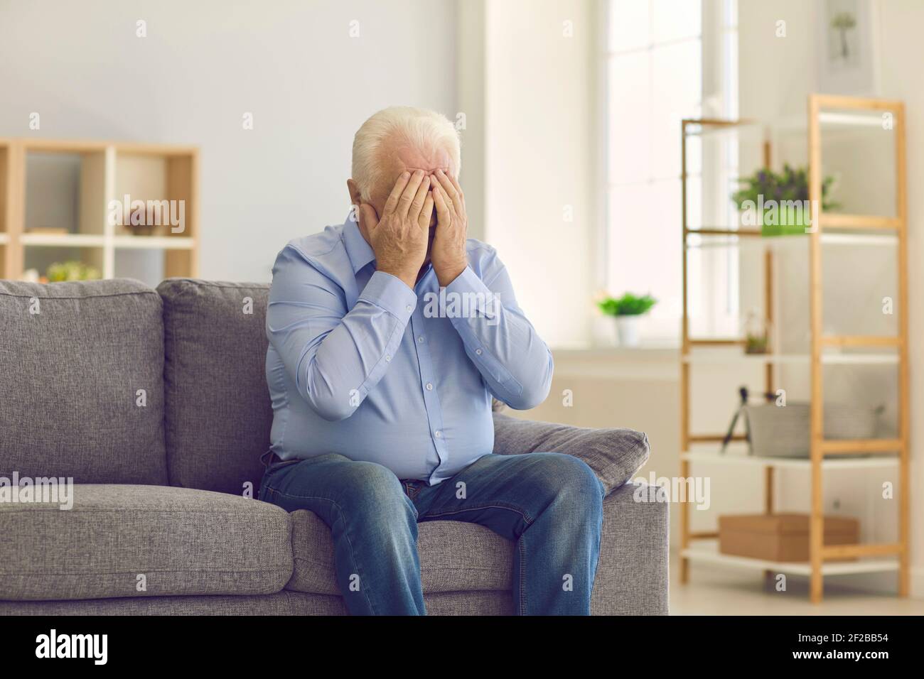 Homme âgé couvrant le visage avec les mains et pleurant, pleurant ou souffrant de maux de tête Banque D'Images