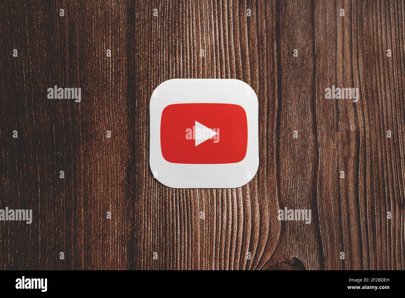 Logo rouge de l'application YouTube imprimé sur le papier placé au centre arrière-plan en bois Banque D'Images