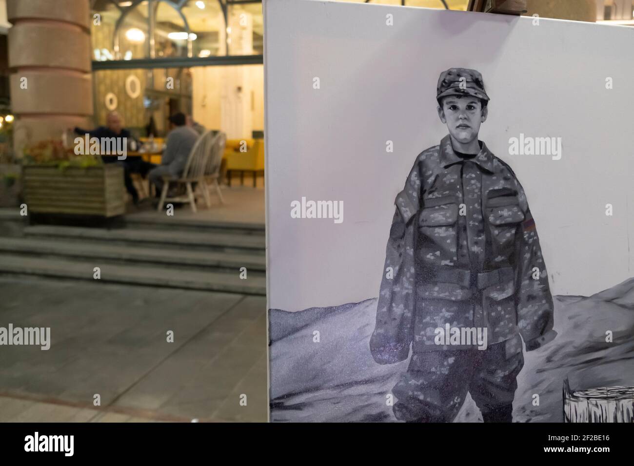 EREVAN, ARMÉNIE - OCTOBRE 30 : un tableau montre un enfant en fatigue militaire près d'un restaurant lors d'un conflit militaire entre les forces arméniennes et azerbaïdjanaises sur l'avenue du Nord, dans la capitale arménienne d'Erevan, le 30 2020 octobre. Les combats entre l'Arménie et l'Azerbaïdjan sur le Haut-Karabakh, également connu sous le nom de République d'Artsakh, ont rééclaté à la fin de septembre pour se transformer en une guerre de six semaines avec les deux pays s'accusant mutuellement de provocation qui a fait des milliers de morts. Banque D'Images