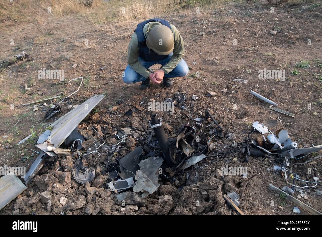 SHUSHI, HAUT-KARABAKH - NOVEMBRE 03 : un arménien portant une veste de protection et un casque inspecte les restes d'un drone de Harop, kamikaze abattu par les militaires de l'Azery dans la banlieue de la ville de Shushi ou de Shusha dans la République autoproclamée d'Artsakh ou du Haut-Karabakh, De jure partie de la République d'Azerbaïdjan le 03 2020 novembre. Les combats entre l'Arménie et l'Azerbaïdjan sur le Haut-Karabakh, également connu sous le nom de République d'Artsakh, ont rééclaté à la fin de septembre pour se transformer en une guerre de six semaines avec les deux pays s'accusant mutuellement de provocation qui a fait des milliers de morts. Banque D'Images