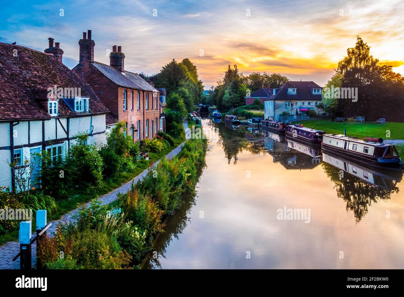 Le soleil se couche sur des bateaux étroits amarrés le soir d'été sur le canal Kennet et Avon dans le centre de la ville de Hungerford, en Angleterre Banque D'Images