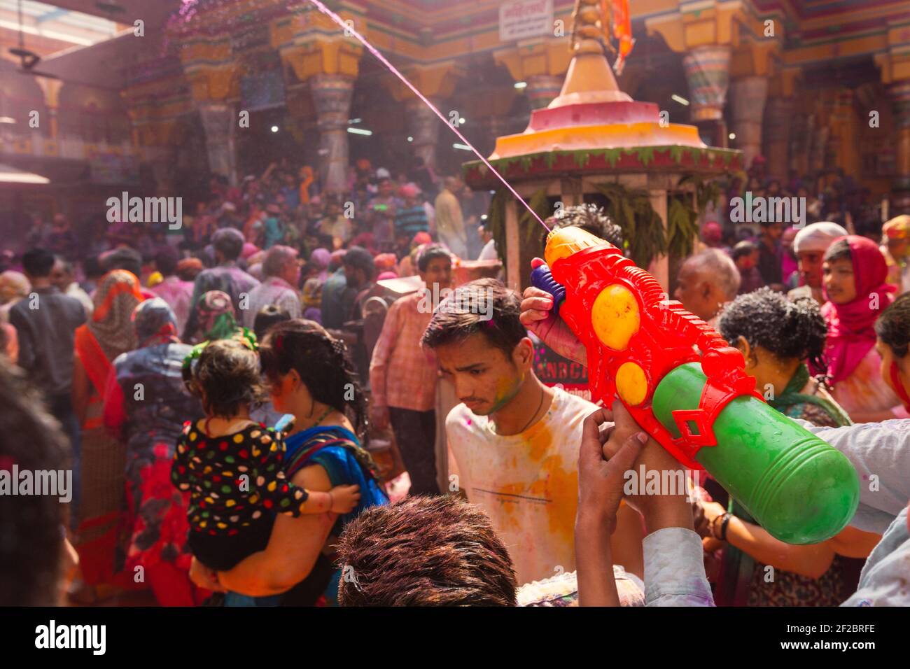 Inde, Mathura - les dévotés célèbrent Holi à l'intérieur du temple de Dwarkadheesh. Les participants dansent, vaporisent de l'eau colorée les uns sur les autres et jettent de la poudre colorée Banque D'Images