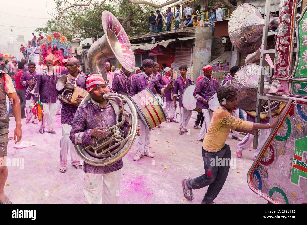 Inde, Mathura - bande de laiton recouverte de poudre colorée jouant dans la procession Holi à Mathura. Banque D'Images