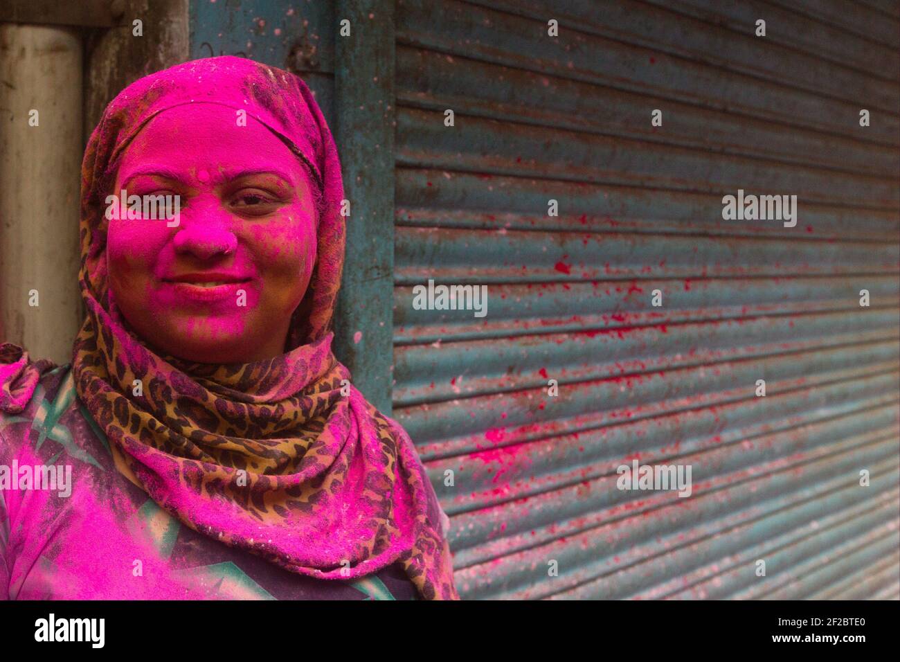Inde, Mathura - Portrait d'une femme couverte de poudre de couleur rose à la procession Holi à Mathura Banque D'Images