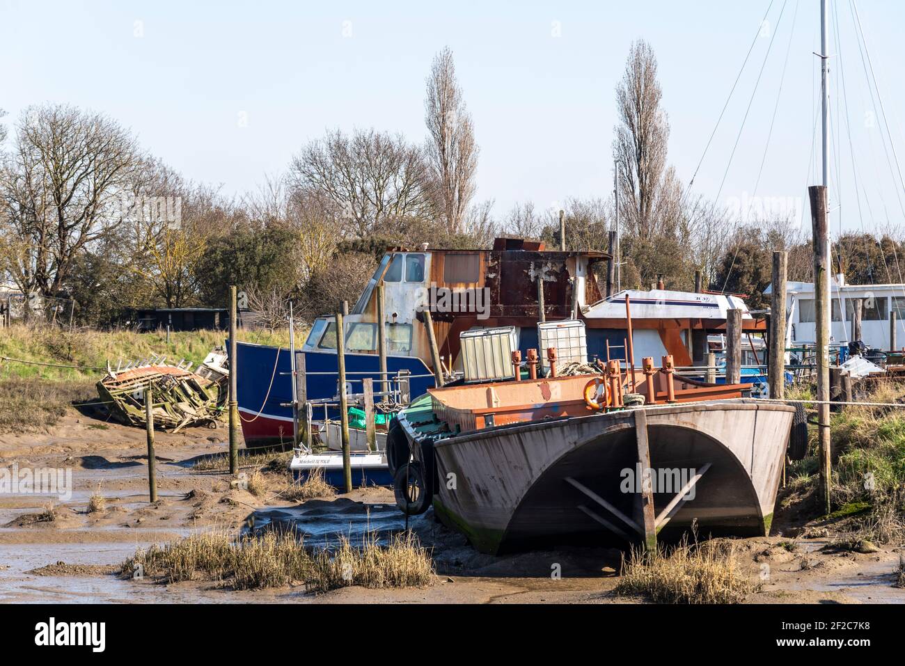 Rivière Roach à marée basse près de Rochford et Stambridge, Essex, Royaume-Uni. Vieux navires en décomposition. Bateaux assis sur la boue au bord du chantier. Barge Banque D'Images