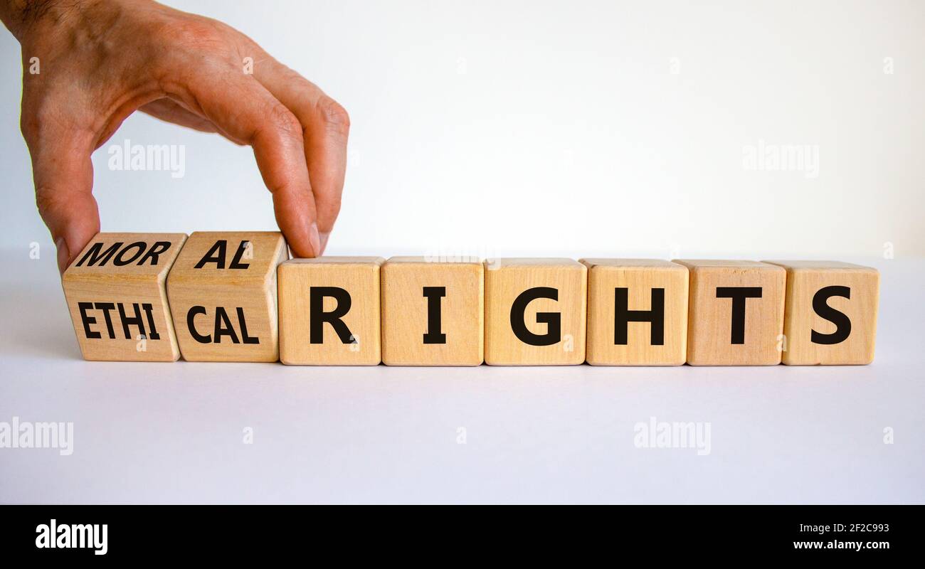 Symbole des droits éthiques ou moraux. Homme d'affaires transforme des cubes en bois et change les mots des droits éthiques aux droits moraux sur un beau fond blanc. Bus Banque D'Images