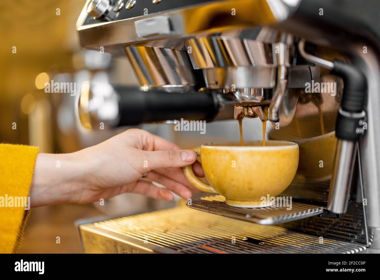 Préparer un espresso avec une machine à café professionnelle à la maison,  en gros plan. La main tient une tasse tout en versant le café Photo Stock -  Alamy