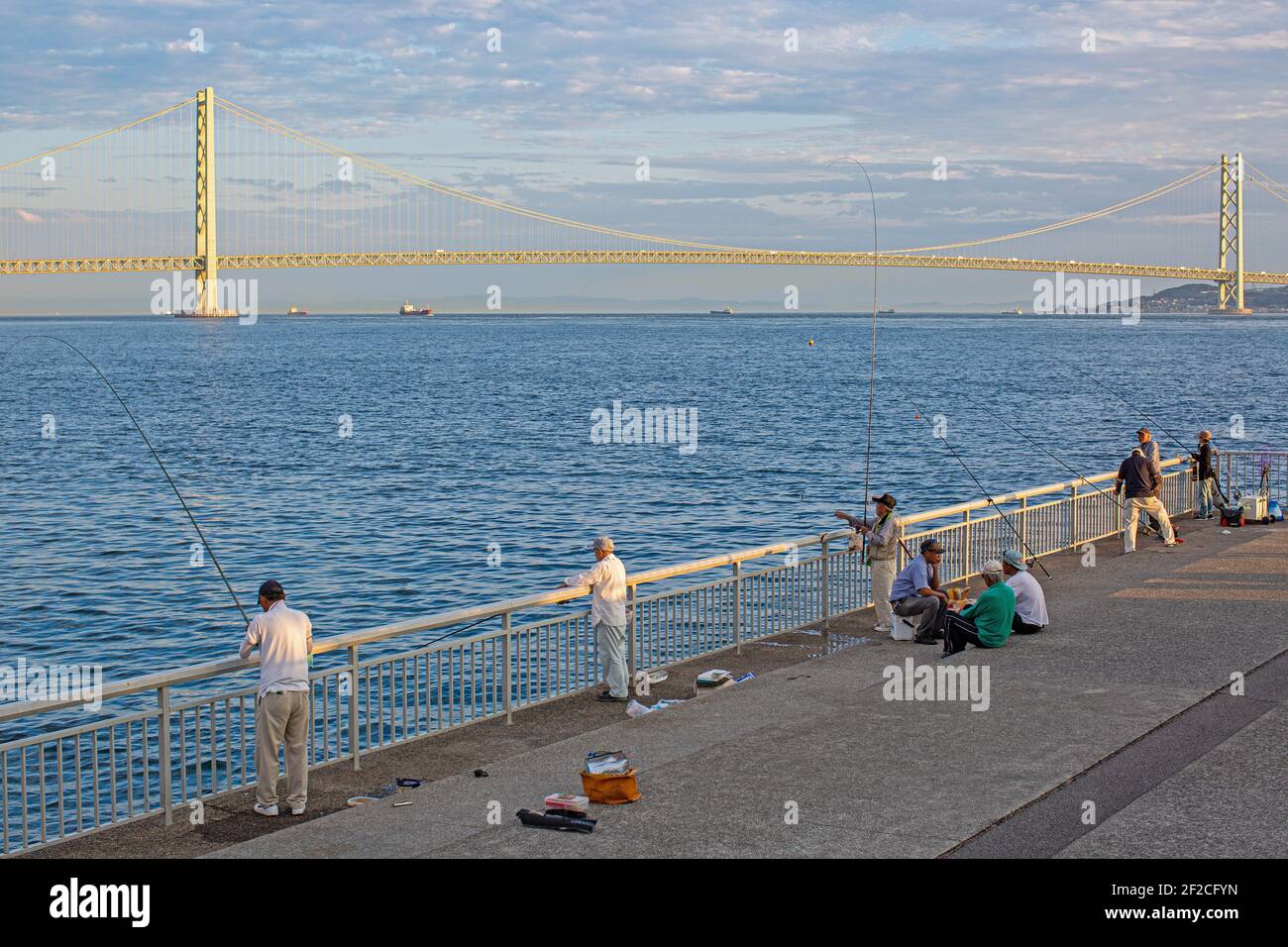 Pêcheur à la ligne dans le fond du pont Akashi Kaikyo dans la matinée d'été. Akashi, préfecture de Hyogo, Japon. Banque D'Images