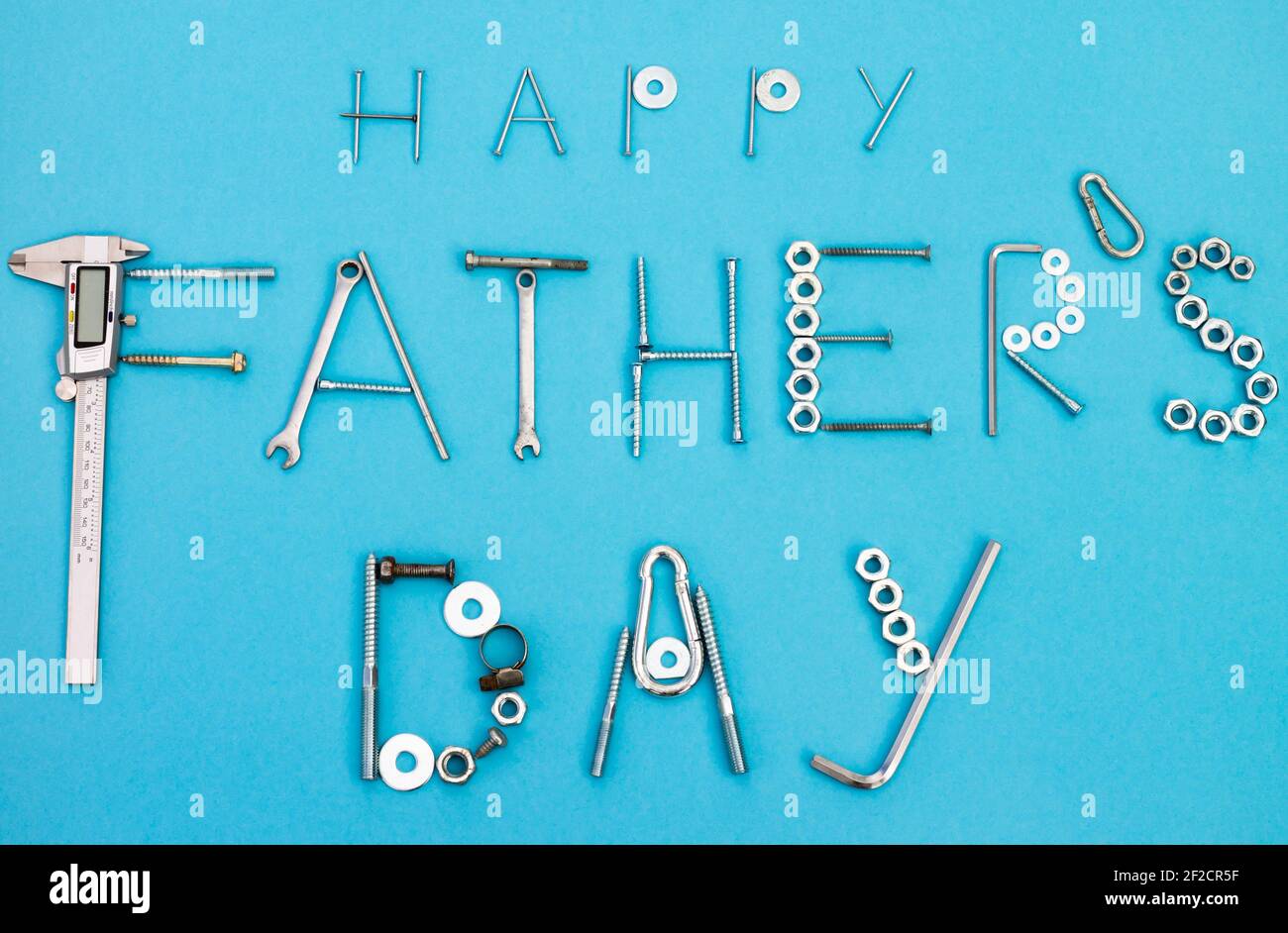 Texte Happy Pather's Day avec boulons, écrous, clés et autres outils de construction sur fond bleu. Pose à plat. Vue de dessus Banque D'Images