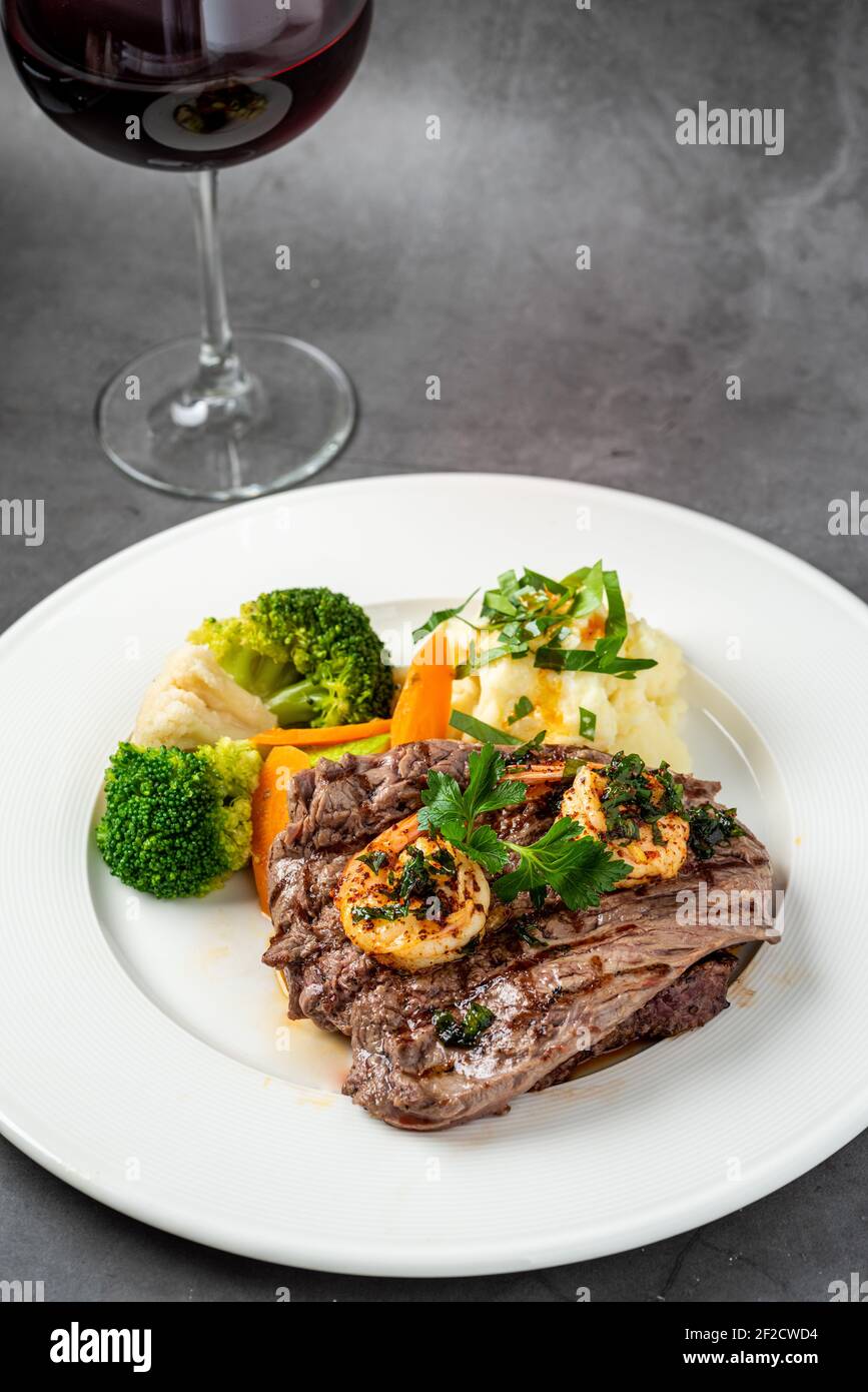 Délicieux steak et crevettes grillés juteux avec brocoli et chou-fleur grillés. Style surf et gazon. Banque D'Images