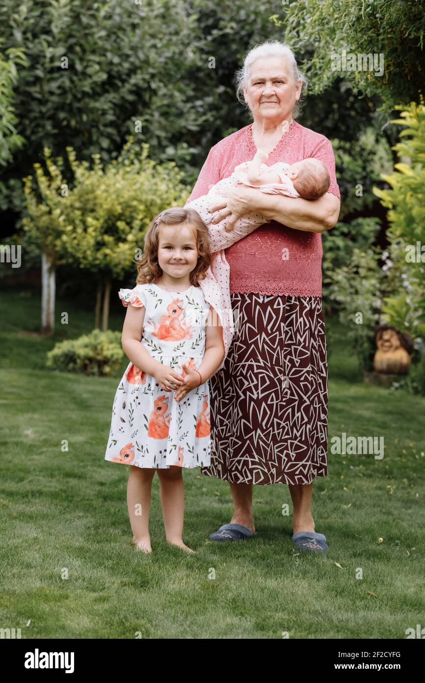Belle Grand Mere Tenant Son Nouveau Ne Petite Fille Mignon Deuxieme Fille Tres Jeune Est Debout A Cote D Elle Heureux Granny Adorable Bebe Fille C Photo Stock Alamy