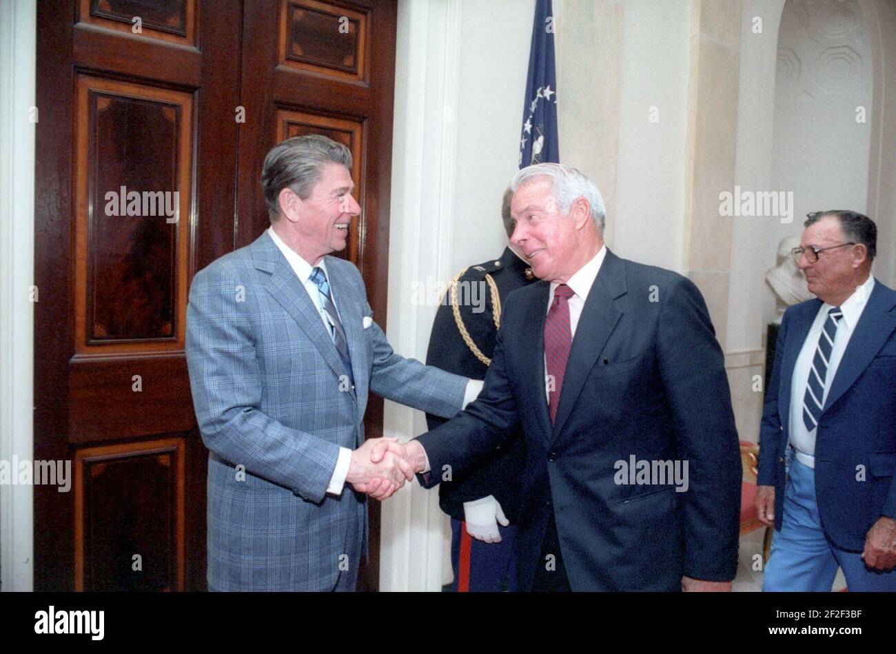 Le président Ronald Reagan se serrer la main avec Joe DiMaggio. Banque D'Images