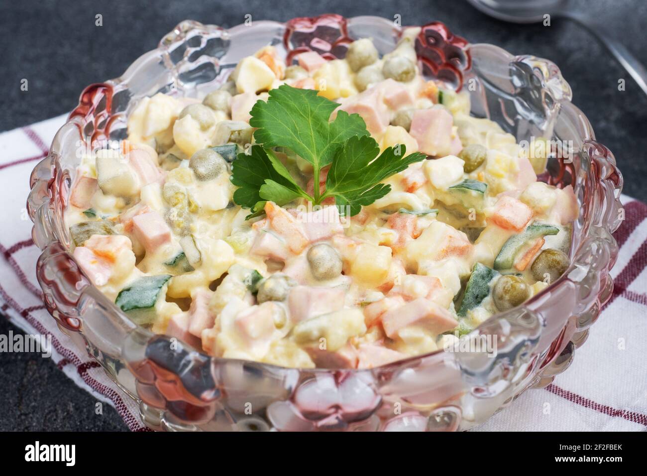 Salade Olivier avec mayonnaise sur une assiette. Le russe est un plat traditionnel de fête Banque D'Images Salade Olivier avec mayonnaise sur une assiette. Le russe est un plat traditionnel de fête Banque D'Images