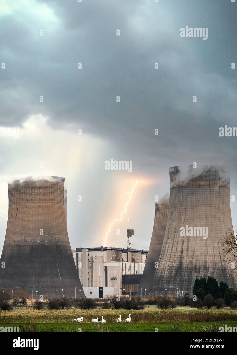 Flash boulon de la centrale électrique éclair avec refroidissement tour de cheminées à vapeur en tempête avec de spectaculaires nuages orageux au-dessus et la faune Banque D'Images