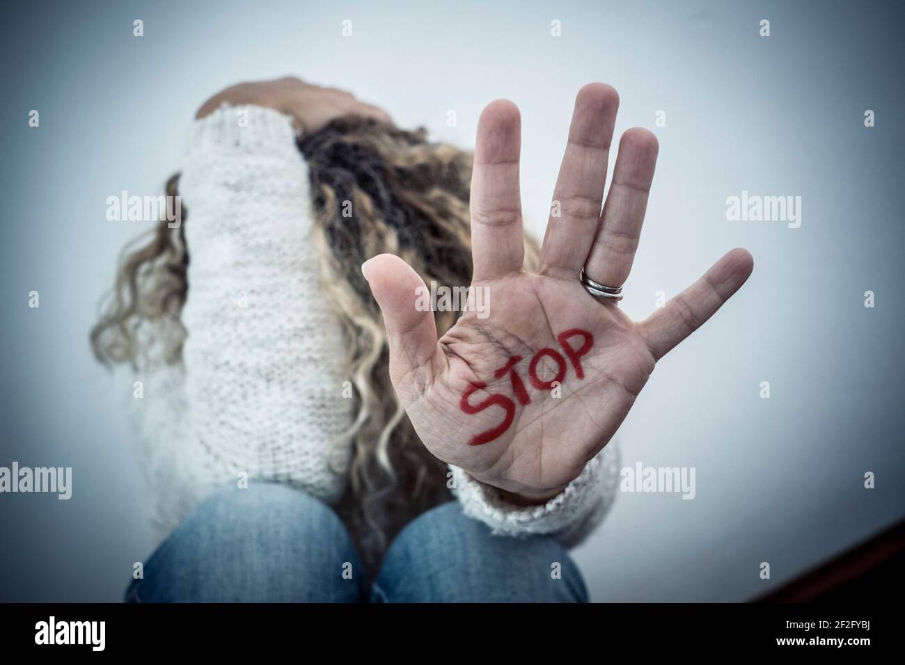 Mettre fin à l'abus de violence de crime sur les femmes des hommes - femme se protéger au sol avec la main pour se défendre - violence à la maison et couple abuese Banque D'Images