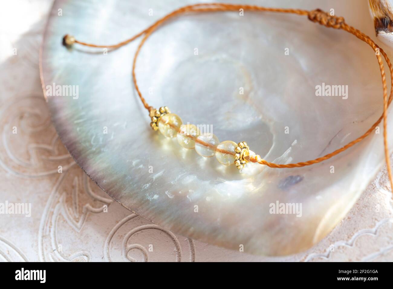 Citrine gemmes perles petit bracelet élégant sur fond naturel de coquillages Banque D'Images