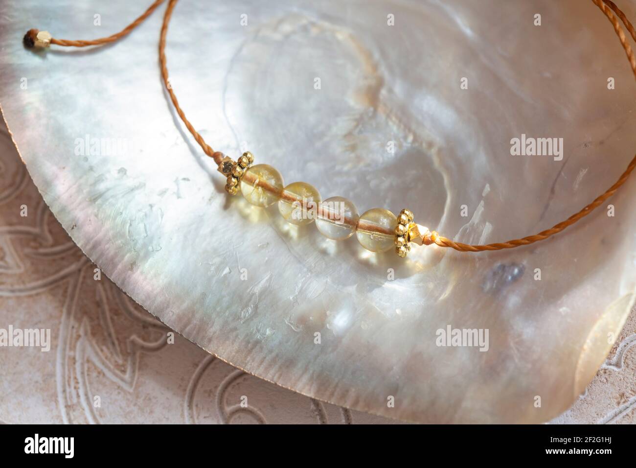 Citrine gemmes perles petit bracelet élégant sur fond naturel de coquillages Banque D'Images