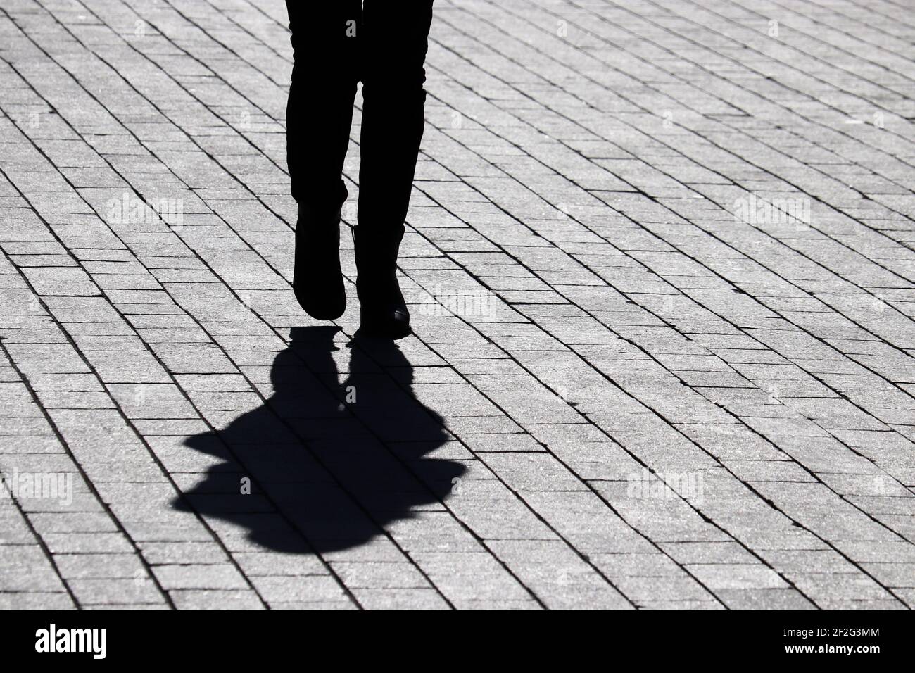 Silhouette noire et ombre d'une femme solitaire marchant dans une rue. Concept de solitude, vie humaine dramatique Banque D'Images
