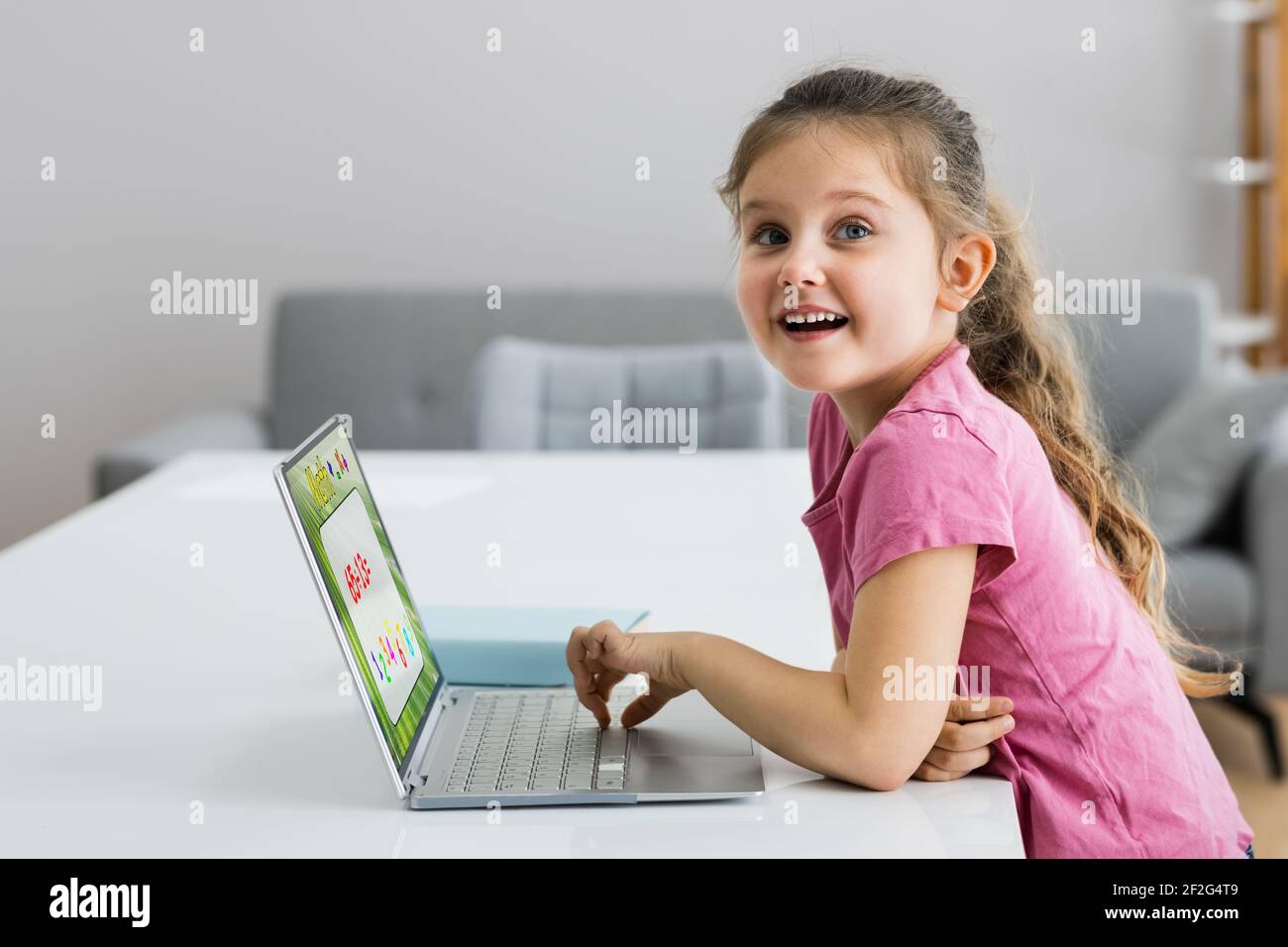 Enfant excité étudiant en mathématiques de résolution sur ordinateur portable Banque D'Images