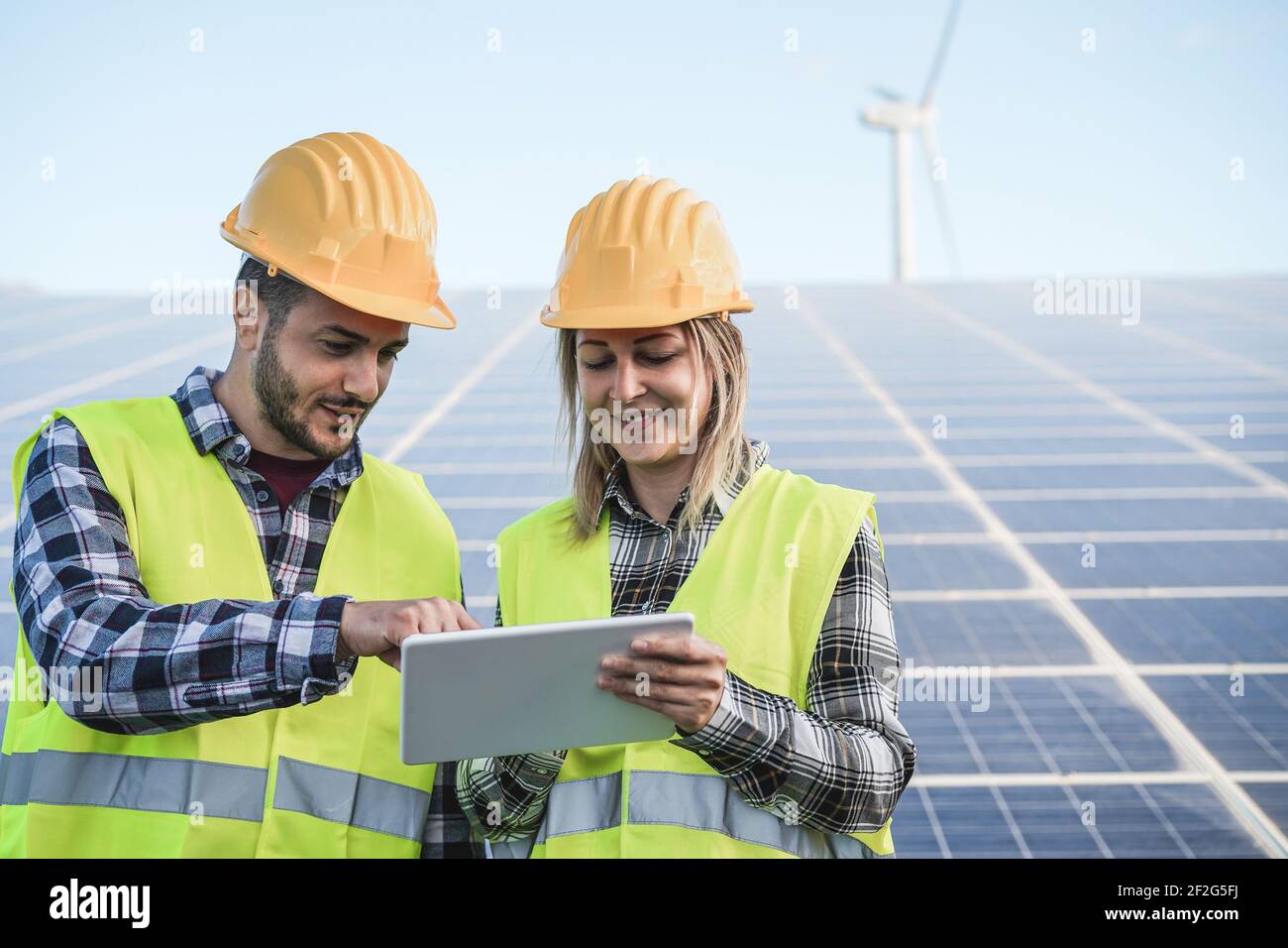 Les jeunes qui travaillent avec des tablettes numériques dans une exploitation d'énergie renouvelable - Focus sur les faces Banque D'Images