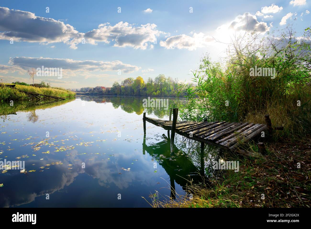 Jetée de pêche en bois ancien sur l étang à nuageux lever du soleil Banque D'Images