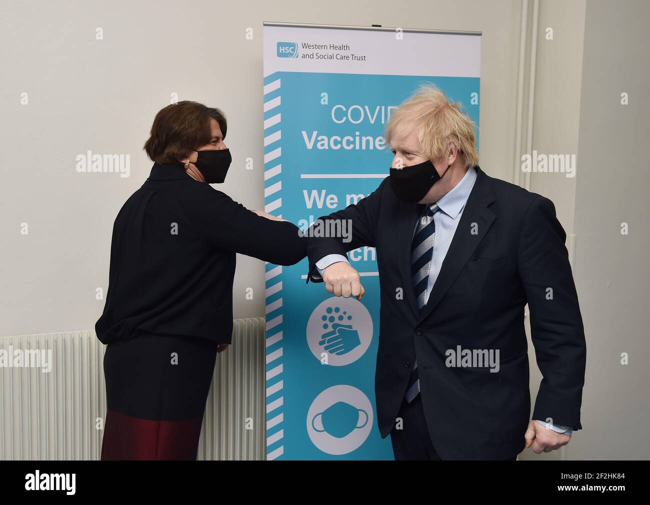 Le Premier ministre Boris Johnson est accueilli par un coup de coude par le Premier ministre Arlene Foster lors d’une visite au centre de vaccination du Lakeland Forum à Enniskillen, en Irlande du Nord. Date de la photo : vendredi 12 mars 2021. Banque D'Images