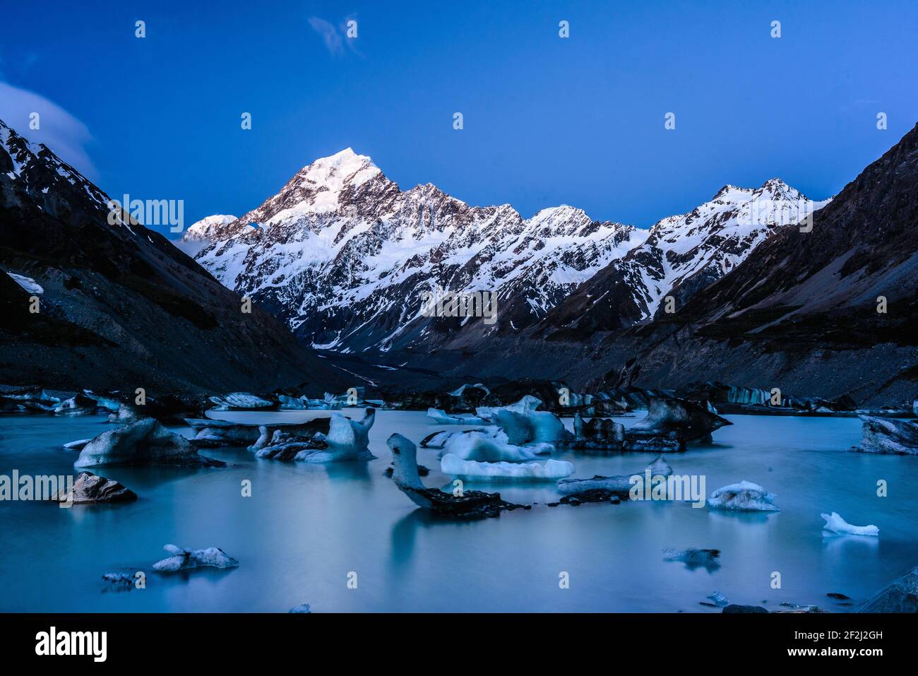 Soleil brillant sur la montagne enneigée massive du Mont Cook/Aoraki. Blocs de glace de forme différente flottant sur le lac Hooker, en Nouvelle-Zélande. Banque D'Images