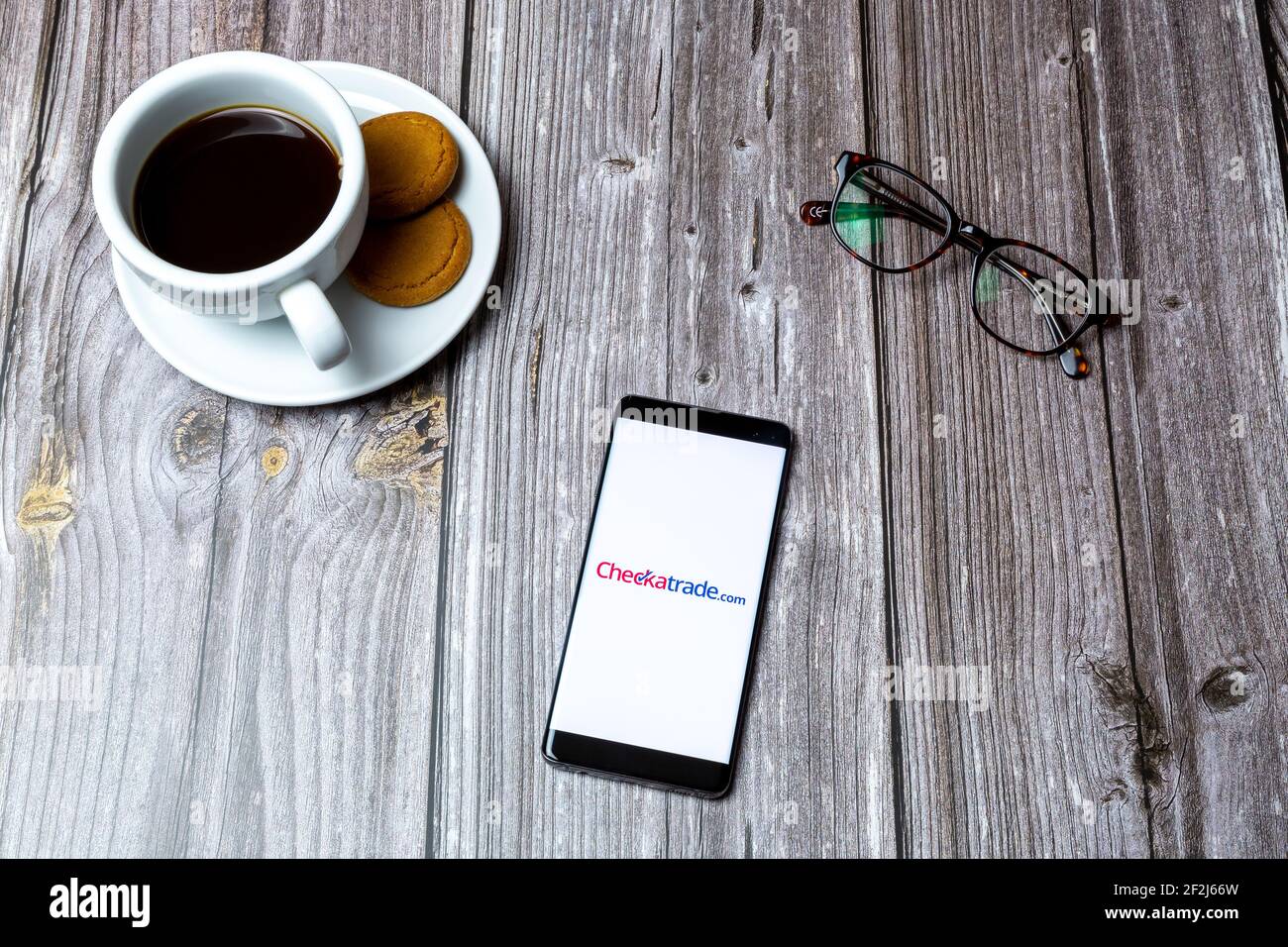 Un téléphone portable ou mobile posé sur un bois Avec l'application Checkatrade ouverte à l'écran Banque D'Images