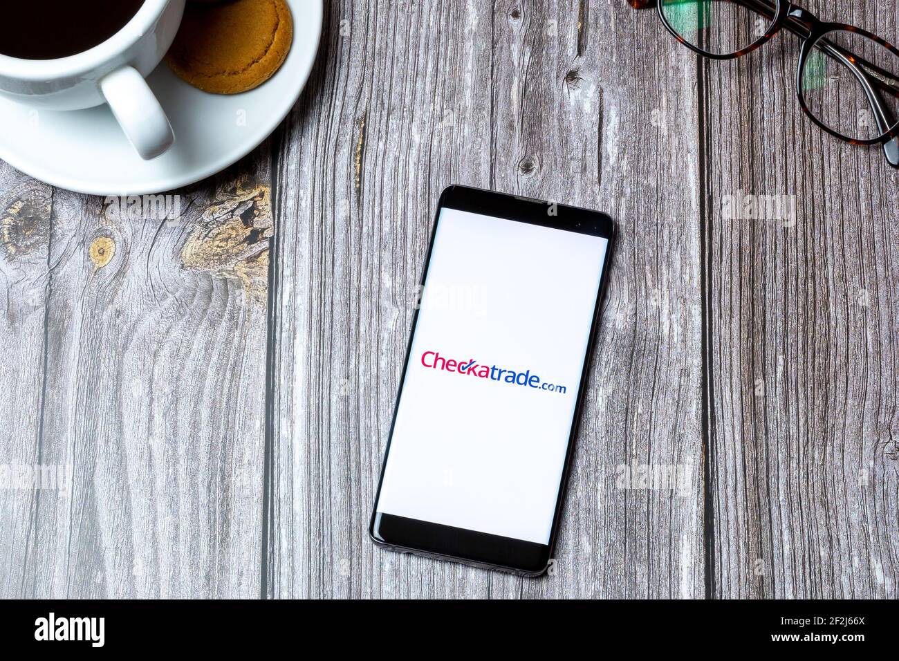 Un téléphone portable ou mobile posé sur un bois Avec l'application Checkatrade ouverte à l'écran Banque D'Images