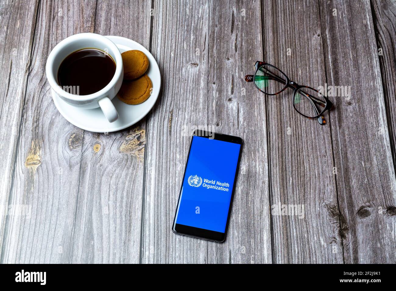 Un téléphone portable ou mobile posé sur un bois Avec l'application de l'Organisation mondiale de la santé ouverte à l'écran Banque D'Images