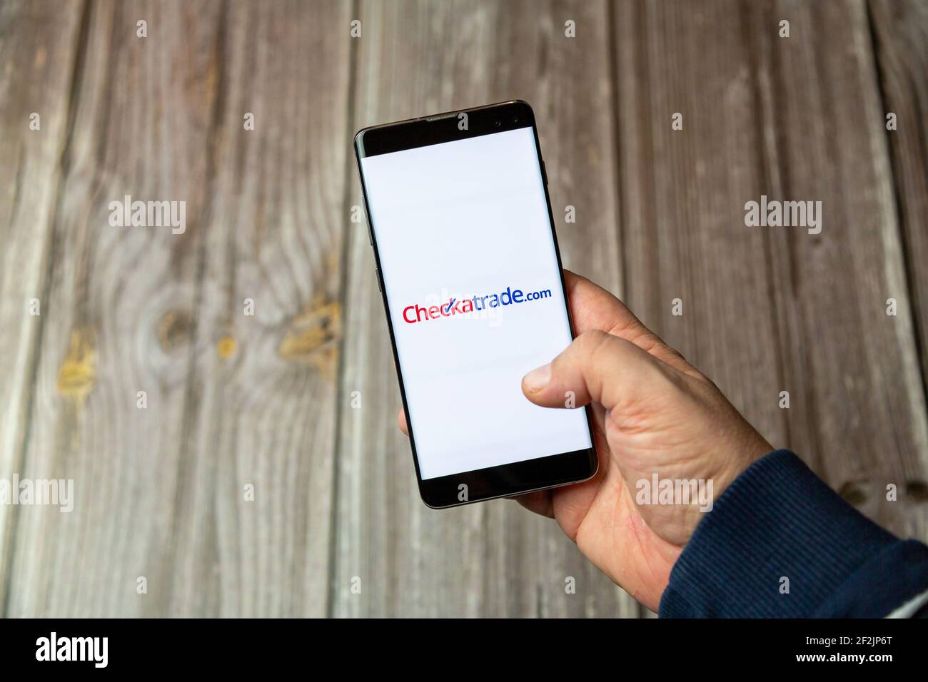 Un téléphone mobile ou mobile tenu dans un Main avec l'application Checkatrade ouverte à l'écran Banque D'Images