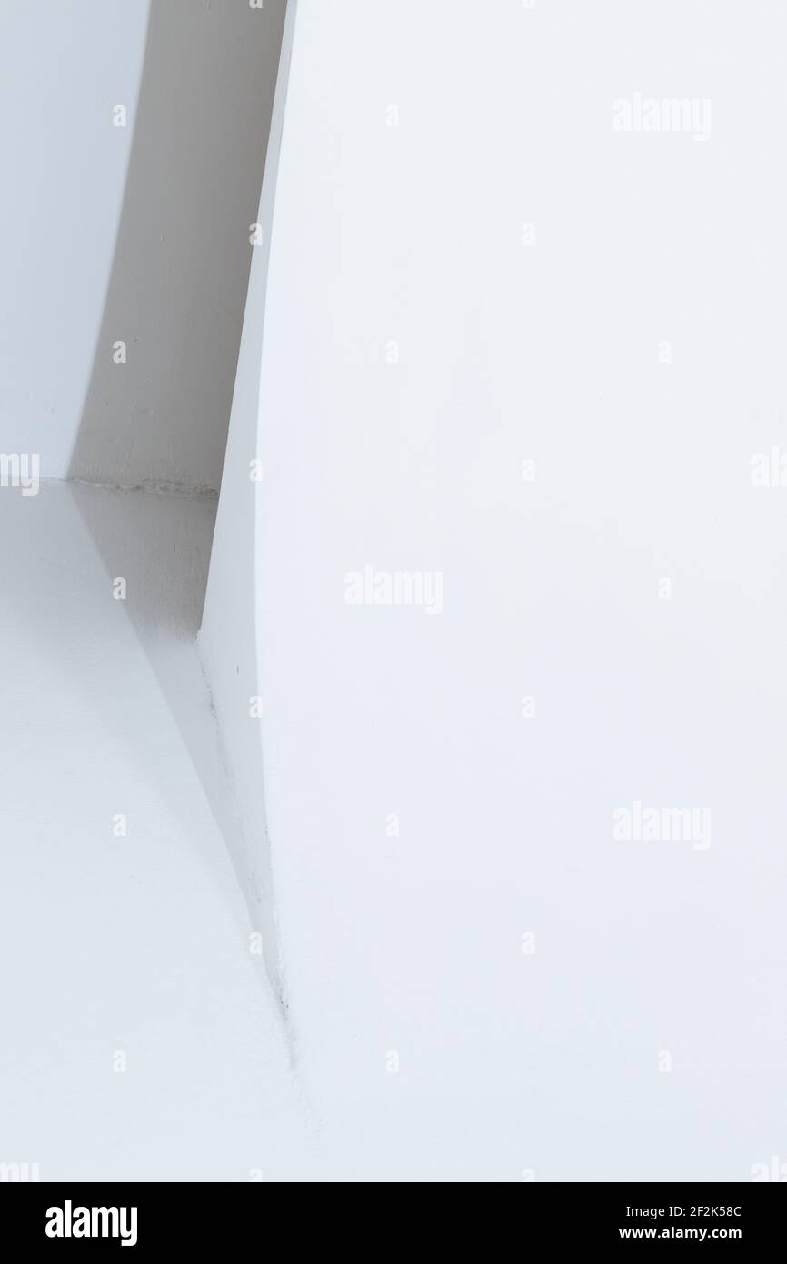 Fragment intérieur de studio blanc abstrait, structure de cyclorama avec transition en douceur entre les plans horizontal et vertical. Fond de ligne vertical Banque D'Images