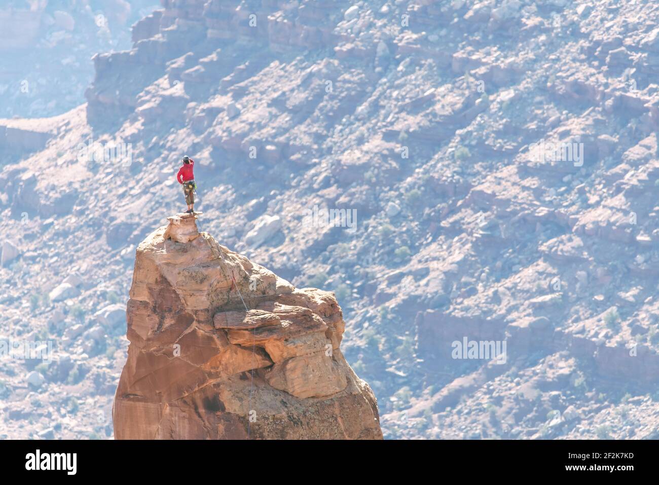 Homme au sommet d'un sommet rocheux au parc national de Canyonlands Banque D'Images