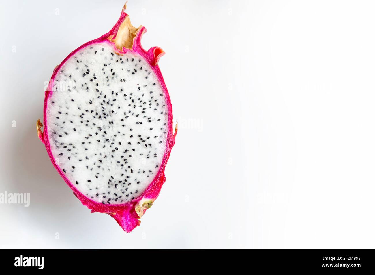 Pitahaya Dragon fruit frais à moitié coupée avec de la pulpe blanche et des graines de palmier sur un fond blanc. Pitaya fruit vue du dessus de la photographie avec un endroit vide pour Banque D'Images