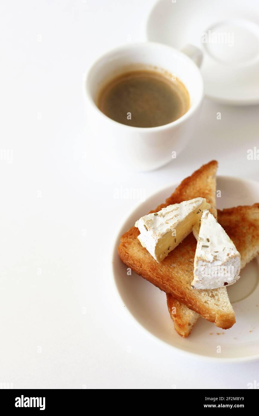 Petit déjeuner. Toast du matin avec fromage à la Brie, tasse de café noir sur fond blanc. Banque D'Images