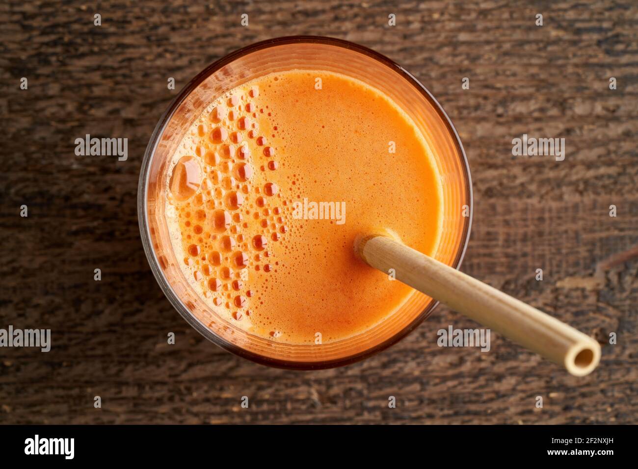 Un verre de jus de carotte avec une paille de bambou, vue de dessus Banque D'Images