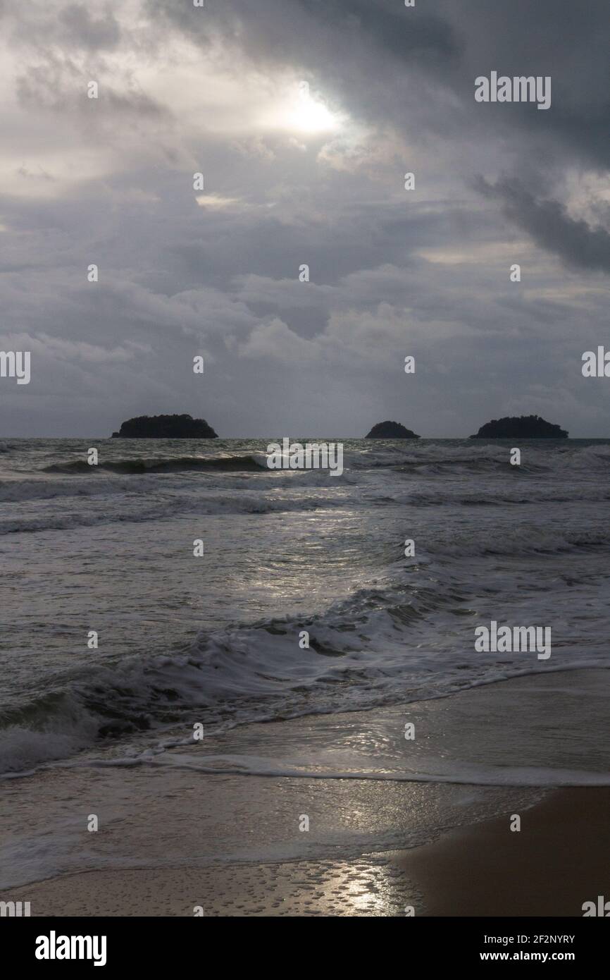 Koh Chang, Thaïlande - 30 juin 2016 : le soleil se coupe à travers les nuages sur une plage. Banque D'Images