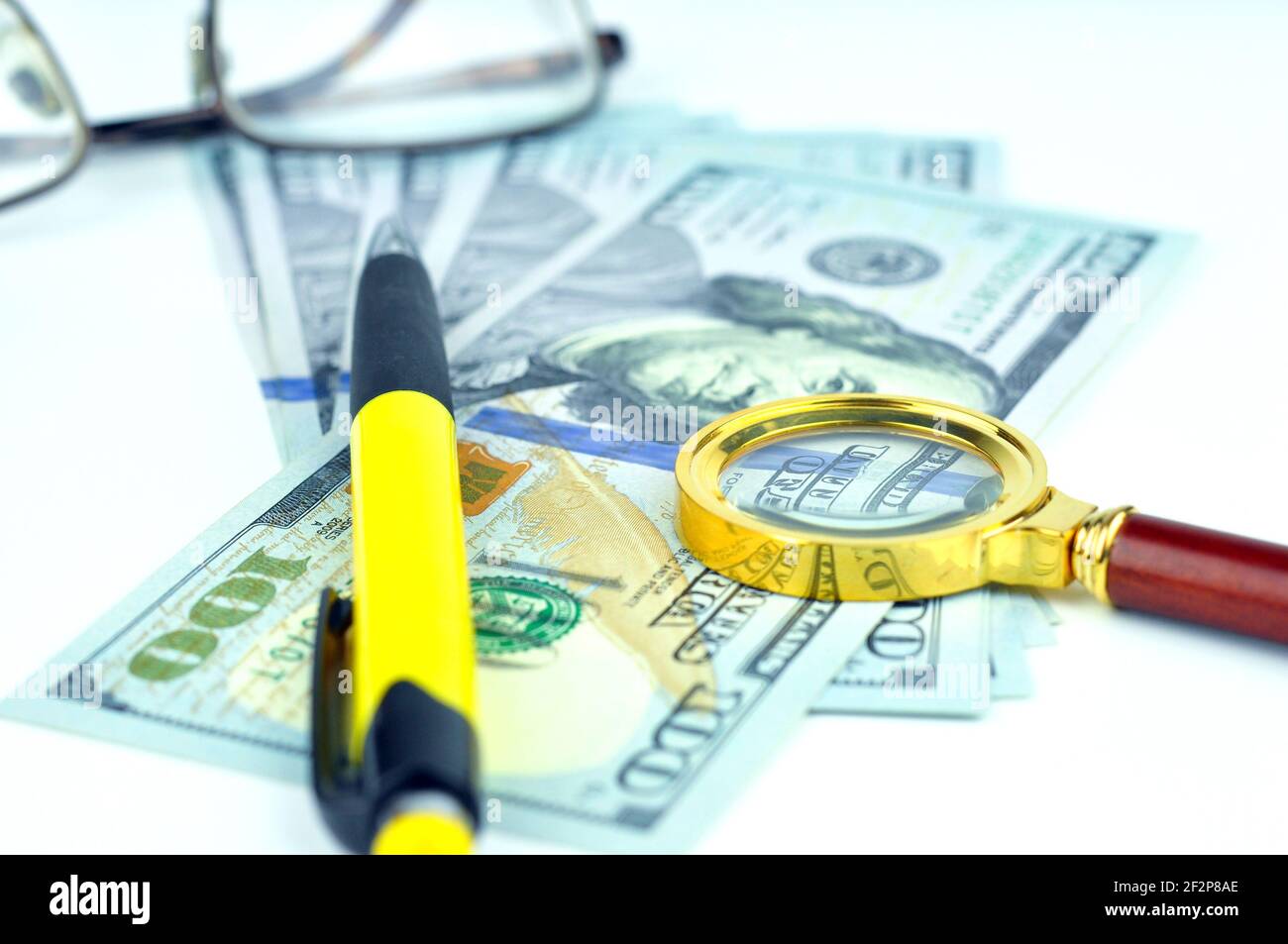 Stylo, loupe et l'argent. Analyse et réussite. Banque D'Images